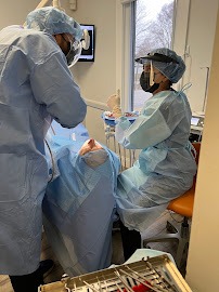 Friendly caring dentist consulting with a mature patient discussing tooth restoration and replacement options in a warm clinical setting